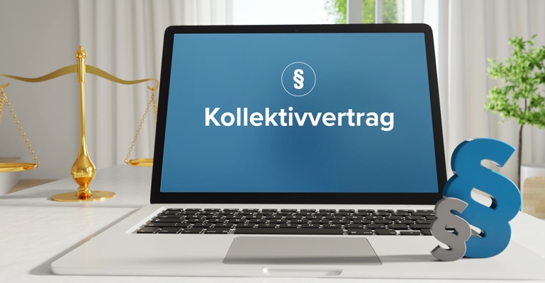 Laptop im Büro mit Begriff Kollektivvertrag auf dem Monitor - daneben Paragraf und Waage